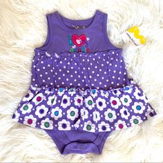 This Is A Brand New With Tags Ruffled Dress Onesie From Kohl’s. It Is Purple With White Polka Dots And White Flowers. It Says I My Auntie On The Front. Fitted Purple Dress For Playwear, Playful Purple Dress For Playwear, Cute Purple Cotton Dress, Cute Purple Dress For Play, Cute Purple Playwear Dress, Purple Cotton Dress For Playtime, Summer Purple Playwear For Babies, Baby Girls Dress, Disney Handbags