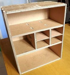 an open cardboard book shelf sitting on top of a wooden table