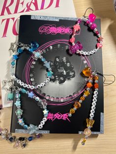 a book with many different bracelets on top of it next to a pair of scissors