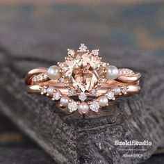 a close up of a ring on top of a rock with pearls and diamonds around it