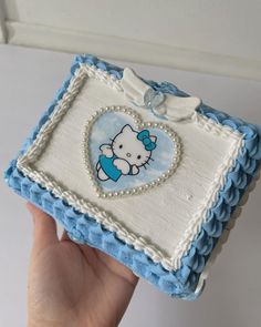 a hello kitty cake is being held up