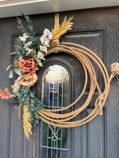 a wreath made out of rope and flowers on the front door with a light bulb