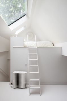 a white room with a ladder to the ceiling and a bed in the loft above it