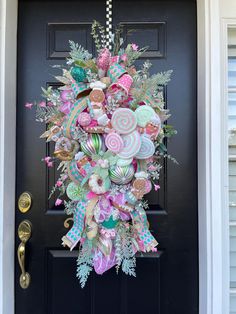 a wreath is hanging on the front door decorated with candy and lollipops