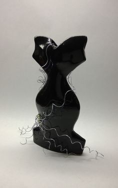 a black glass sculpture sitting on top of a white table