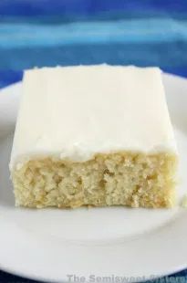 a piece of cake sitting on top of a white plate next to a blue table cloth