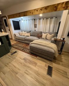 a living room filled with lots of furniture next to a kitchen counter and stove top oven