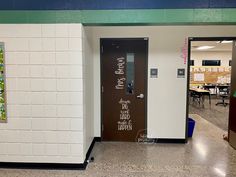 an empty hallway in a school with writing on the door