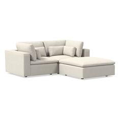 a white sectional couch with pillows on it's back and the seat facing outward