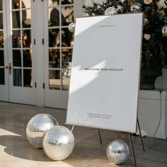 three shiny disco balls sitting in front of a welcome sign with the words welcome screen mockup on it