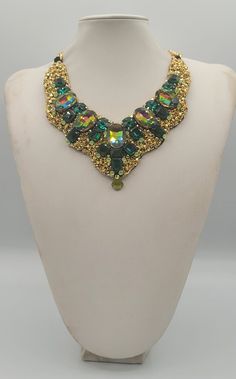 Each piece of our statement necklaces is handmade and one of a kind made in Italy. Our creations is made of high quality materials such as crystals and rhinestones. Each embroidered material is carefully hand sewn. Very glamorous and stylish. Perfect gift to someone you like. Materials Strass stone and Rhinestone in Emerald, Rainbow and Peridot  color in different dimension.  Black satin fabric backing. Aluminium chain with lobster closure. Measurements Weight approximate 200 grams. Chain lenght 25 cm - 9.84 in Circumference approximate 63 cm - 24.80 in Feel free to contact us if you have any question. Thank you so much for looking at our shop and our articles each of them, single piece. Crystal Jeweled Necklaces For Celebration, Costume Jewelry Jeweled Choker Necklace, Handmade Choker Bridal Necklace For Party, Handmade Bridal Choker Necklace, Handmade Bridal Choker Necklace For Party, Handmade Bridal Choker For Party, Handmade Crystal Necklaces For Parties, Luxury Handmade Beaded Necklaces For Party, Unique Beaded Party Necklaces