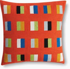 an orange pillow with multicolored squares on it