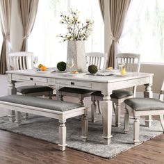 a dining table with four chairs and a bench in front of the table is shown