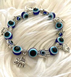 Evil Eye Charm Bracelet, Blue Charm Bracelet, Handmade Blue Bohemian Charm Bracelet, Adjustable Charms Bracelets For Festival, Handmade Blue Evil Eye Bracelet For Festival, Handmade Bohemian Blue Evil Eye Bracelet, Handmade Blue Bohemian Evil Eye Bracelet, Symbolic Blue Bracelet Jewelry, Handmade Blue Stretch Bracelet For Festivals