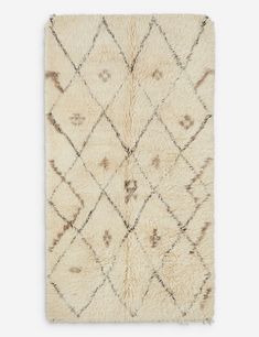 a white rug with brown and beige designs on it, in the shape of diamonds