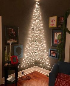 a living room with a christmas tree in the corner and lights on the wall above it