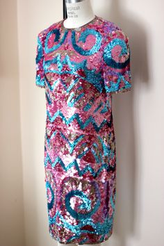 "So fun and so funky!! Vintage 80 sequin/bead hot pink, blue, silver dress! Sooo shiny and sparkly. You will definitely be the center of attention in this unique piece! 100% silk Zips in the back and is in Very good condition! I do not see any sequin loss. Hot pink silk lining Stunning geometric design with beautiful details Measuring: 38\" long Bust: 34\" Waist: 30\" Hip 36\" Pet free/ smoke free Enjoy!" Festive Pink Dress With Contrast Sequin, Festive Pink Dresses With Contrast Sequin, Party Season Pink Dress With Contrast Sequin, Pink Dress With Contrast Sequins For Party Season, Pink Sequin Dress With Glitter For Holidays, Holiday Pink Sequin Dress With Glitter, Pink Party Dress With Contrast Sequin, Pink Sequin Glitter Dress For Holiday, Pink Festive Dress With Sequins