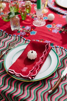 a table set with red napkins and place settings