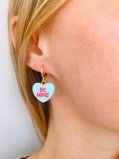 Obsessed is an understatement! Pay homage to your favorite Valentine's Day candies with these adorable be mine huggies. Available in both pierced hoops or clip on styles (for those without their ears pierced) these earrings are super fun and eye catching. Choose from a matte candy heart in a number of different colors or a two color glitter heart. The perfect size they are noticeable without being overwhelming. The charms are lightweight and easy to wear. Hoops are gold plated and nickel free. M Valentines Day Earrings, Ears Pierced, Dagger Earrings, Star Candy, Gold Clips, Glitter Hearts, Heart Candy, Be Mine, Newport Beach