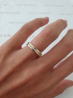 a woman's hand with a gold ring on top of her finger and the word love