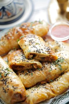 several pastries on a plate with dipping sauce