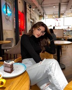 a woman sitting at a table with a piece of cake