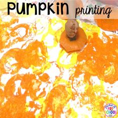 a child is painting pumpkins with orange and yellow paint on the surface, while holding a finger