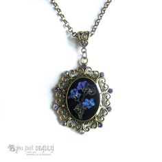 "An ornate Victoriana cameo necklace from the Bijou Botanicals range. This necklace features an arrangement of real, pressed forget-me-nots set against a black background. A Swarovski crystal drop bead hangs from the pendant. Bronze plated chain with extender and custom BBD hang tag! SIZING Chain length: 41cm (16\") Extender length: 5cm Approx size of pendant: 3.7 x 3cm PACKAGING Presented in an organza pouch and includes a polishing cloth. PLEASE NOTE: This item is made to order and takes an ad Vintage Charm Flower Pendant Jewelry Gift, Vintage Flower Pendant Jewelry As Gift, Vintage Charm Jewelry With Flower Pendant For Gift, Vintage Flower Charm Necklace For Gift, Flower Shaped Necklace With Vintage Charm As Gift, Flower Shaped Necklace With Vintage Charm For Gift, Vintage Flower Jewelry Keepsake, Bohemian Cameo Jewelry For Gifts, Bohemian Cameo Jewelry Gift