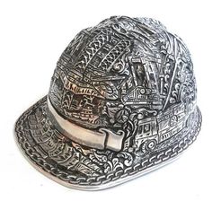 a silver hat with an intricate design on the brim and side panel, sitting against a white background