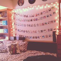 a bed room with a neatly made bed and lots of pictures hanging on the wall