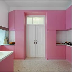 a kitchen with pink cabinets and white counter tops on the walls, along with a sink