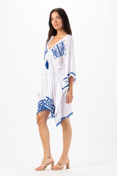 Elevate your beach wardrobe with our Mykonos Mini Dress. This exquisite embroidered coverup allows you to embrace the artistry of seaside fashion. With its intricate detailing and effortless charm, this coverup is sure to make you feel like a beach goddess wherever your adventures take you. Details: 100% Rayon Hand Wash in Cold Water and Lay Flat to Dry Features: Unlined, V-neckline, Embroidered detail, Tassel tie closure to cinch waist for an adjustable fit, Sides drape lower, Billowing short s Embroidered Kaftan For Beach Cover-up, Blue Boho Dress For Beach Cover-up, Embroidered Beachwear Cover-up For Beach Season, Summer V-neck Embroidered Kaftan, V-neck Dress With Floral Embroidery For Beach Season, Embroidered Kaftan For Beach Season, V-neck Embroidered Dress For Beach With Embroidered Hem, Floral Embroidered V-neck Dress For Beach, Embroidered V-neck Beachwear Cover-up