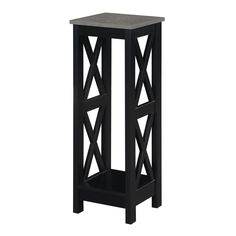 a black side table with an x design on the top and one shelf below it