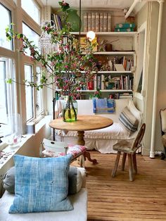 a living room filled with lots of furniture and a table in front of a window