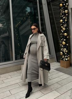 If you're looking for chic winter and fall outfits with black sock boots that are fit to wear during pregnancy, this classy look with a grey sweater dress is a great choice! Plus, if you're after more inspo, read on for more. Cute Fall Pregnancy Outfits, Winter And Fall Outfits, Chic Pregnancy Style, Black Sock Boots, Fall Maternity Outfits, Business Chic Style