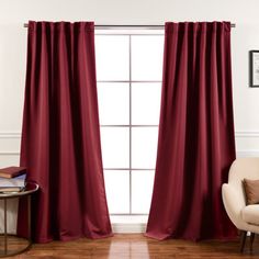 a living room with a chair and red curtains