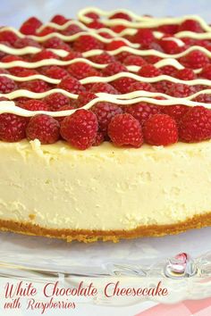 a white chocolate cheesecake with raspberries is on a glass platter, ready to be eaten