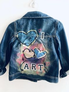 Inspired by my daughter's love of art!This is a thrifted Gap Kids denim jacket in a size 5.I hand painted and spray painted the back and added patches and a cat button to both the front and back.All patches are reinforced by hand stitching. This piece should be hand washed. All jackets are one of a kind. Personalization is free. Artistic Denim Outerwear For Spring, Artsy Cotton Denim Jacket For Spring, Artsy Long Sleeve Cotton Denim Jacket, Artistic Cotton Spring Outerwear, Artistic Cotton Outerwear For Spring, Artistic Fitted Denim Jacket For Spring, Spring Artistic Denim Jacket With Custom Artwork, Artistic Denim Jacket With Custom Artwork For Spring, Artistic Hand Painted Fitted Denim Jacket