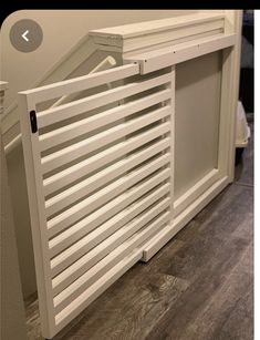 a white radiator sitting on top of a wooden floor next to a wall