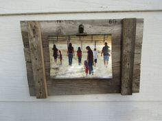 a group of people walking down a street in front of a white building with wood frame