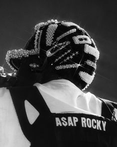 black and white photograph of a person wearing an asap rocky vest with sequins on it