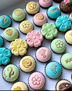 there are many decorated cupcakes in the box on the table with each one's own name