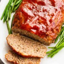 meatloaf with green beans on a white plate