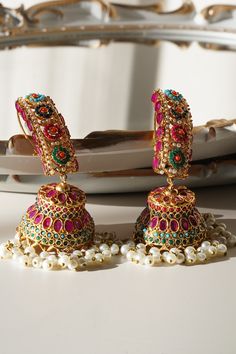 Elevate your style with our exquisite "Roya - Jhumka Earrings." These heritage-inspired jhumka earrings are the perfect fusion of tradition and elegance. Crafted to perfection, they come in three primary color options: ruby, green, or gold, allowing you to choose the perfect match for your ensemble. Key Features: Available in ruby, green, or gold Approximately 3.5 inches Adorned with beautiful multi-color stones and embellishments High-quality antique gold plating Stunning and unique jhumka earr Ear Chain, Accessories Ear, Chandbali Earrings, Elegant Blouse Designs, Color Stones, Choker Necklace Set, Jhumka Earrings, Stone Gold, Green Gold