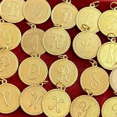 gold plated initial necklaces with monogrammed letters on red velvet background, closeup