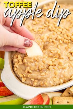 a hand dipping an apple into a bowl of oatmeal