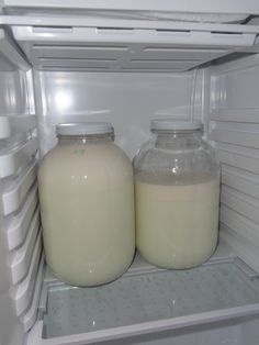 two bottles of milk are sitting in the refrigerator