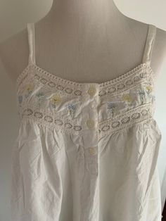 This adorable white cotton nightgown has an embroidered bodice with floral stencils on the bottom of the skirt.   Ruffle bottom edge.  So pretty! Tagged a size medium.    Label: Gilligan O'Malley Bust flat is 16 inches. No stretch Underbust is 17 inches. Short bodice please note! Straps do not adjust. Strap drop is 7.5 inches  Length is 32-33 inches No issues.  Nice cotton. Appears slightly yellowing.  Maybe a bit faded as well especially at bottom floral stencil area.  Sold as is. No returns. F White Cotton Sleepwear For Summer, White Cotton Sleepwear With Floral Embroidery, Cottagecore White Sleepwear With Lace Trim, White Cottagecore Sleepwear With Lace Trim, Cottagecore White Nightgown With Lace Trim, Summer Cotton Nightgown, Casual White Floral Print Nightgown, White Lace Trim Sleepwear For Spring, Cottagecore Cotton Nightgown For Bedtime