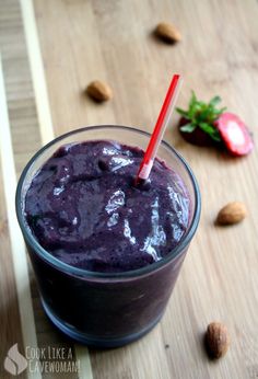 a smoothie in a glass with strawberries on the side