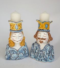 two ceramic figurines with candles in the shape of king and queen crowns on them